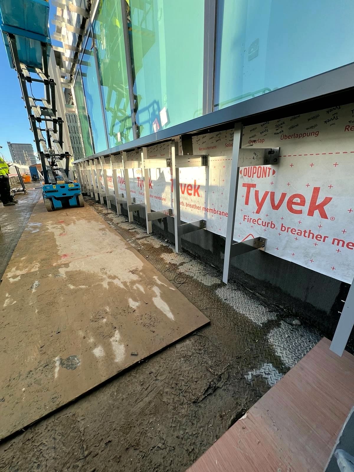 Ground-level facade run with barriers below curtain-wall glazing